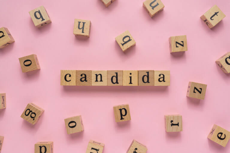 A fungus called Candida, which causes yeast infections, is written on a wooden block.