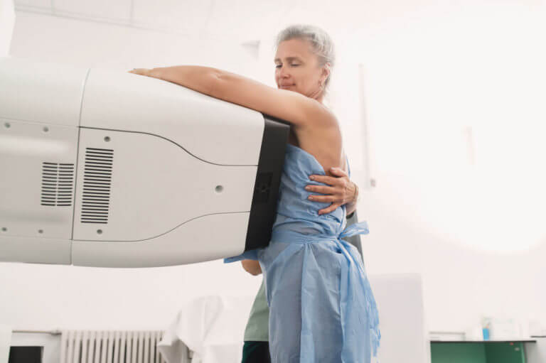 A nurse helps a patient undergo a mammogram procedure.